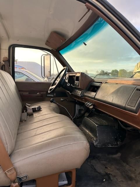 Interior of a 1991 Chevrolet Kodiak truck showing the driver and passenger seats, steering wheel, dashboard, and gear shift.