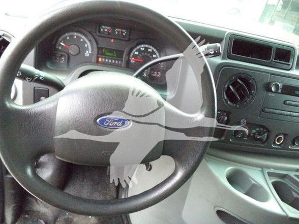 Ford E-Series van/dump truck interior visible steering wheel with Ford emblem, dashboard gauges, and center console controls.