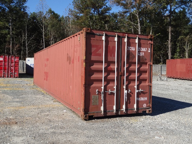 Used cargo container in a storage yard with other containers in background.