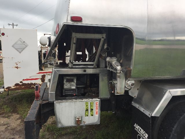 Freightliner FL-70 fuel truck rear showing access platform, control box, hoses, and metal framework.