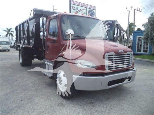 Freightliner Business Class M2 106 dump truck in red with chrome grille and silver bumper, front-right view, decal windows covering truck image.