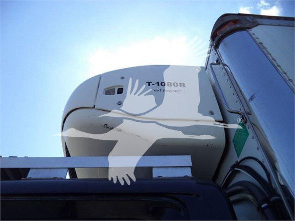 Truck reefer unit T-1080R Whisper air curtain on top of trailer with blue sky background.