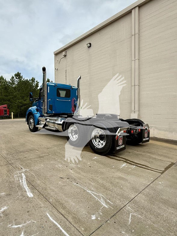 Kenworth T880 conventional daycab tractor in blue with dual rear axles and chrome fuel tanks, side view showing cab and chassis.