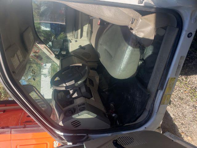 Interior of a 2008 Ford F550 cab showing driver seat, steering wheel, dashboard, and front door open.