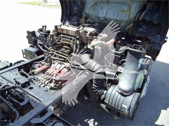 Isuzu NRR engine bay showing diesel engine and air intake components.