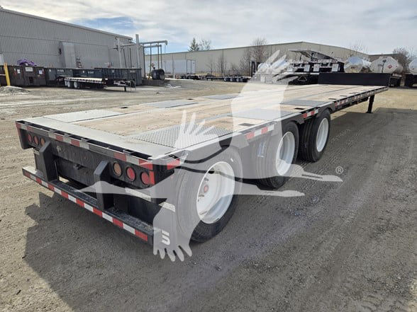 Tri-axle steel drop deck trailer showing rear and side with tandem axles and flat deck.