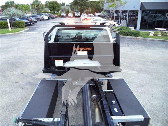 Truck towing equipment with a hydraulic system and flatbed cargo area, viewed from rear with Jordan logo on soft top; VIN visible in listing.