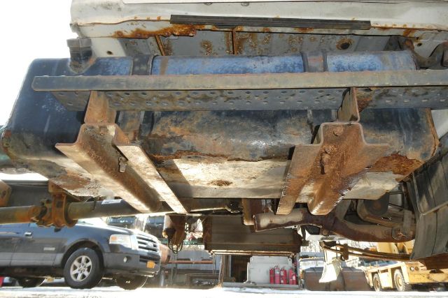 Underbody view of a 2007 Hino 145 cab and chassis showing rusty frame and suspension components.