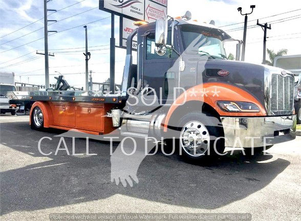 Peterbilt 337 tow truck in side view with orange lower body and chrome wheels. The word SOLD overlayed across the image with a watermark.
