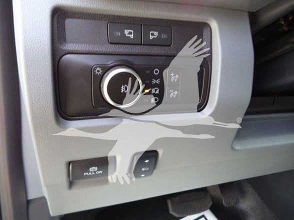 Ford F-450 interior dash controls with headlight knob and auxiliary switches.