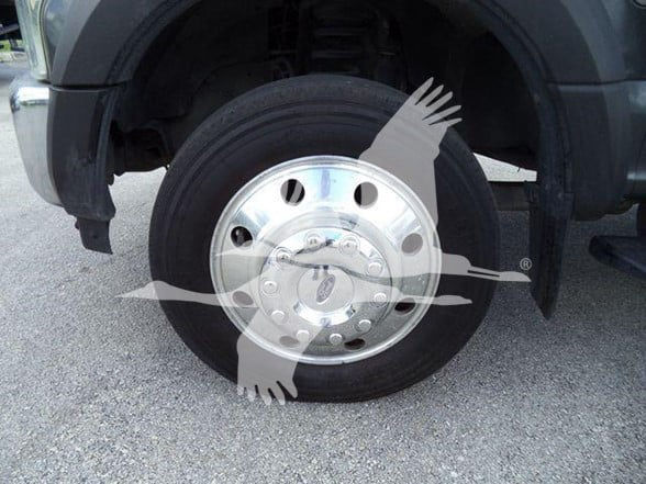 Ford F-450 wheel and tire showing chrome cover with hub and lug nuts.