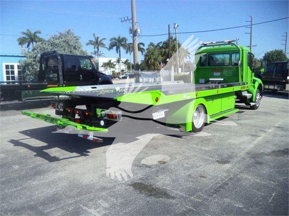 Green 2025 Kenworth T280 tow truck with flatbed in a lot, rear view showing hydraulic ramps and winch system.
