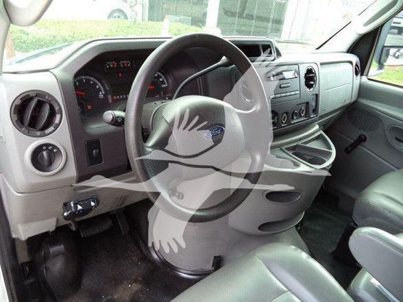 Dashboard and steering wheel of a Ford E-series van/truck cab showing steering wheel, instrument cluster, and center console.