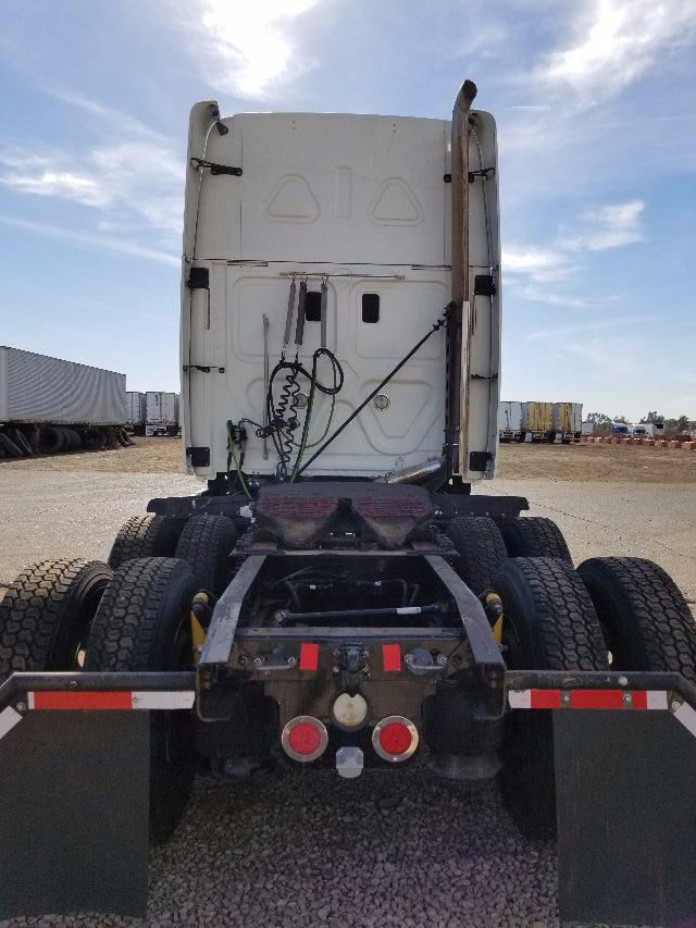 Rear view of a 2012 Freightliner Cascadia conventional sleeper truck. Visible are the dual rear axles, fifth-wheel hitch area, taillights, and rear bumper.