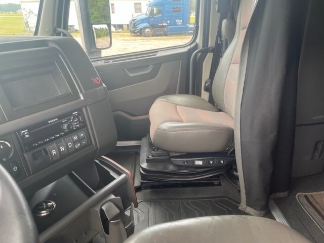 Volvo VNL64T740 truck interior cab view showing driver seat, dashboard, and gear selector area.