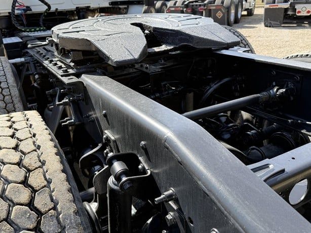 Truck chassis showing fifth wheel area and drivetrain on a 2021 International Lonestar, with visible frame rails, suspension, and large tires.