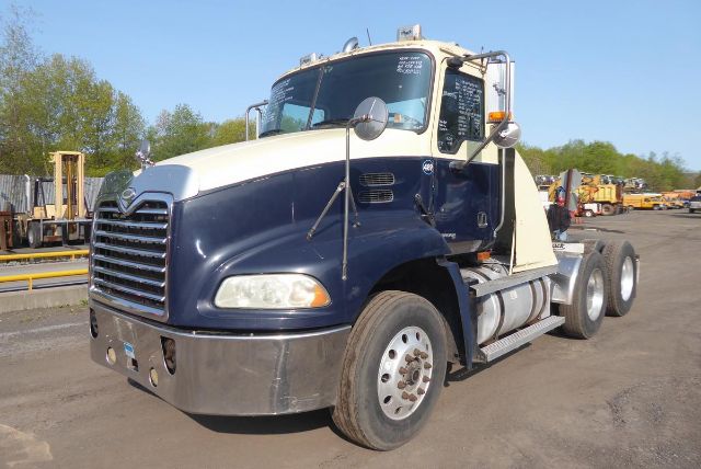 Mack CXN613 daytime cab truck in blue and white with dual rear axles, chrome front bumper, and large side fuel tank. VIN 1M1AK06Y77N019993 displayed.