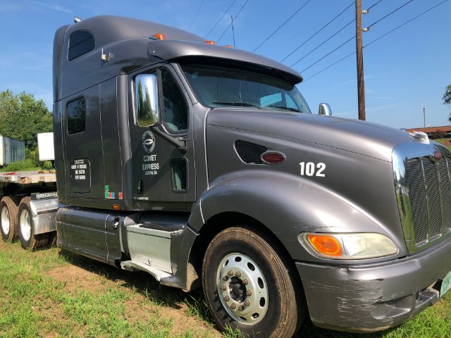 Peterbilt 387 truck in profile view with gray paint, number 102 on front fender, chrome grille, sleeper cab, and side decals