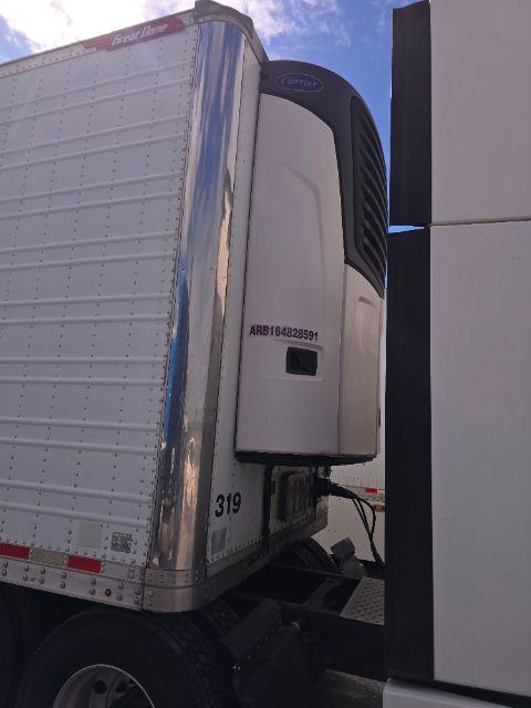Great Dane trailer refrigeration unit on the front of a reefer trailer with black rider curtain and white body.