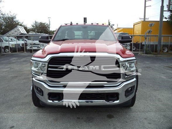Ram heavy-duty truck front view showing large grille with RAM emblem, chrome bumper, and headlights. Overlay watermark partially obscures center.