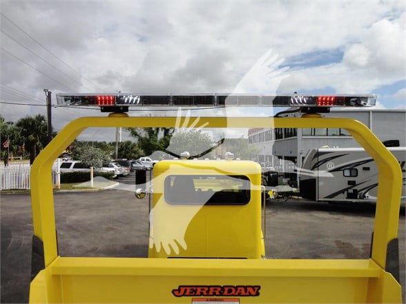 Rear view of a yellow Jerr-Dan tow truck bed with rear light bar and window hatch.