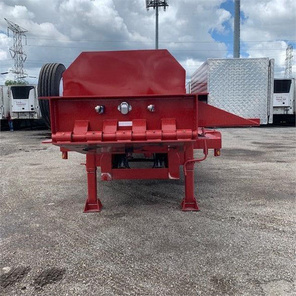 Red drop deck container delivery trailer rear view showing support legs, hitch, and wheel on single axle.