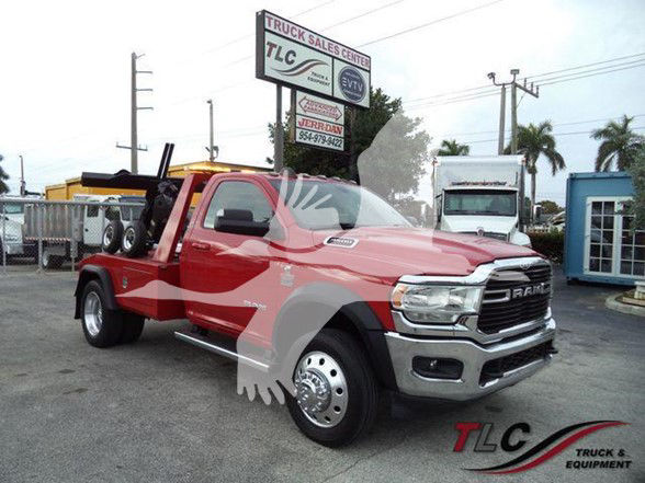 Ram 4500 truck in red with flatbed, parked at TLC Truck Sales Center lot. Signage in background reads TLC Truck Sales Center.
