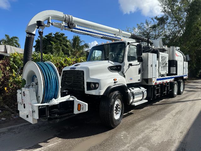 Freightliner 114SD vacuum truck with large hose reel and reclaiming unit on a sunny day.
