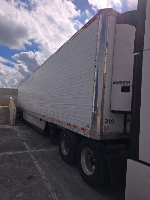 2016 Great Dane SS trailer side view parked with white corrugated aluminum walls and rear doors; visible wheelset and tractor in foreground.