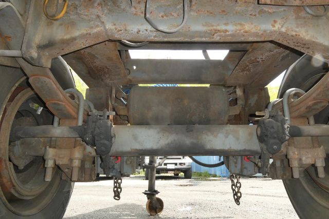 Trailer rear view showing axle, suspension, and hitch components under Fruehauf ELFI dolly. Visible components include axles, leaf springs, and hitch braces.