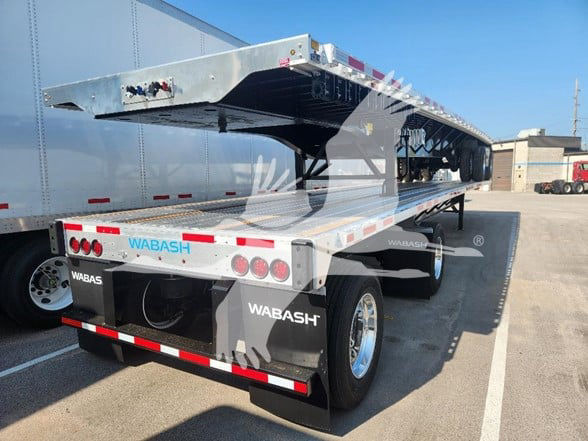 Wabash flatbed trailer with lowered gooseneck and rear lights. Visible text includes WABASH on mudflaps and rear bumper, and WABASH branding on the frame.