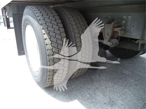 Dual rear wheels on trailer showing tire treads and suspension components.