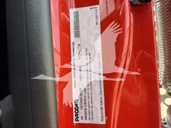 Label on red Kenworth truck door jamb with barcode and PacLease sticker showing serial barcodes and text.