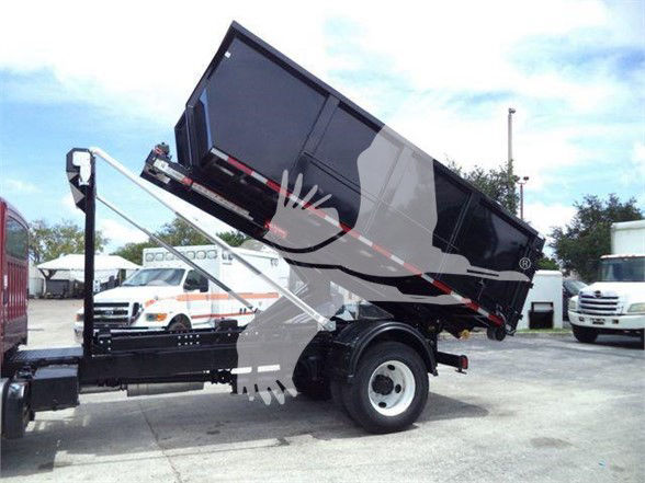Freightliner BUSINESS CLASS M2 106 dump truck with a raised black dump bed and hydraulic system. View shows side and front wheels, with other trucks in background.