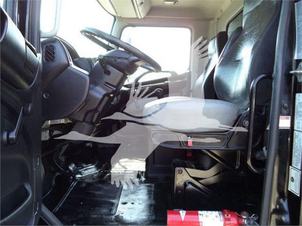 Truck cabin interior showing driver seat and steering wheel with floor, dashboard, and passenger seat visible.