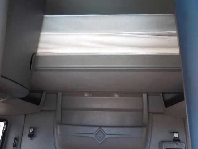 Interior sleeper cab area of a 2010 International PROSTAR showing overhead bunk space and storage panels.