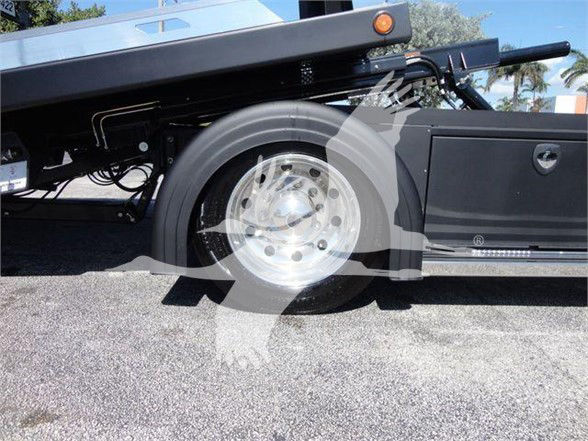 Wheel and side storage compartment of a 2022 International MV tow truck showing alloy wheel and low-profile body frame.