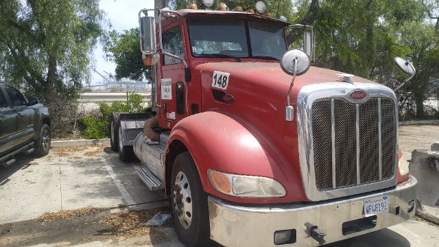 Peterbilt 386 conventional daycab truck in red with chrome grille, front bumper, and side mirrors. Visible text: number 148 on door, license plate on bumper, windshield wipers, dual headlights.