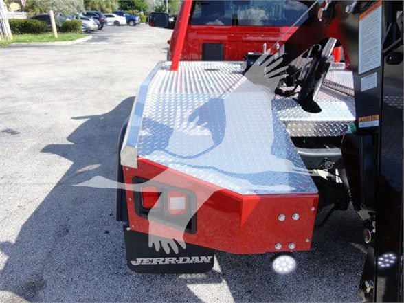 Ram 4500 tow truck rear platform with diamond plate metal surface and red bumper showing Jerry-Dan mudflap and lights.