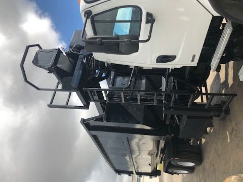 Grapple truck showing white cab and black dumping bed with crane and ladder attached.