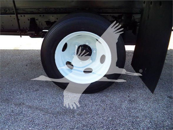 Isuzu truck wheel and undercarriage with white steel rim, black tire, and mudflap visible.