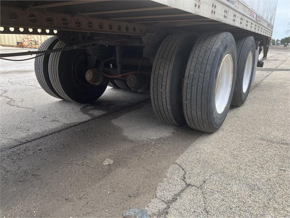 Wabash dry van trailer rear axles and dual tires, undercarriage visible with twin axle configuration and wheel rims.