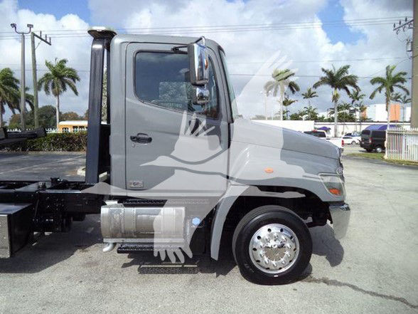 Tractor truck cab side view showing Hino 258ALP chassis with front-right wheel and fuel tanks.