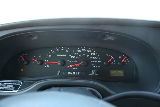 Dashboard of a 2005 Ford E350 showing gauges: speedometer up to 110 mph, tachometer, fuel gauge, temp gauge, gear indicator P R N D 3 2 1, small digital odometer readout.