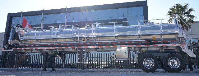 Vacuum trailer side view showing stainless aluminum tanker with twin axles and ladder rails.