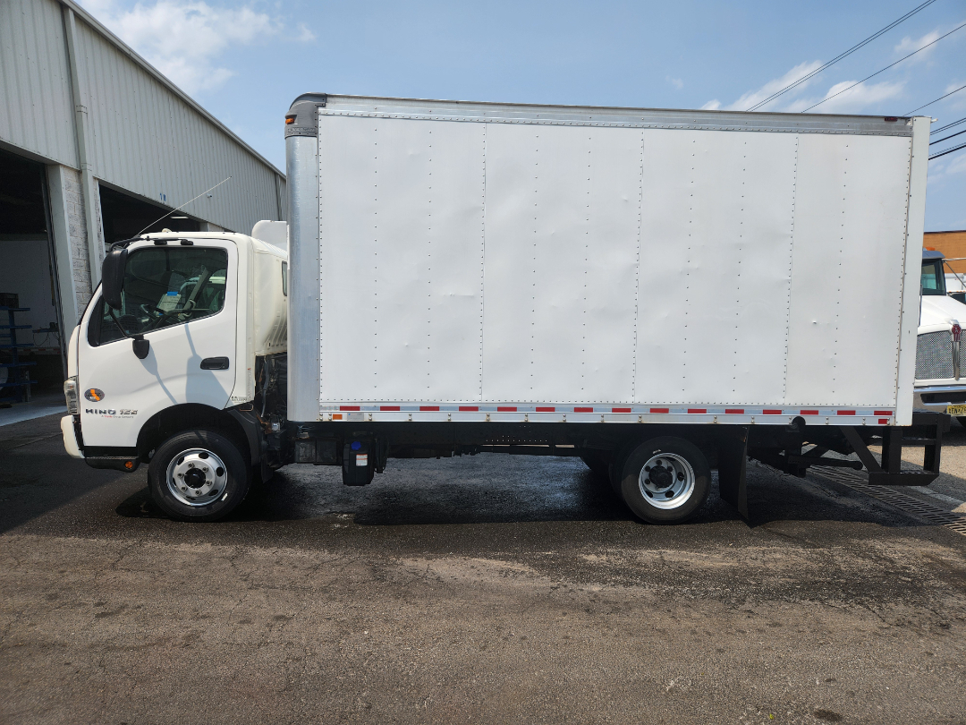 Box truck side view showing white cab and large enclosed cargo box on a Hino 155 chassis.