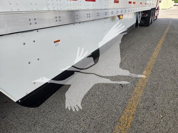 Wabash trailer side with lower skid and painted image of a jumping bear silhouette along side of vehicle.