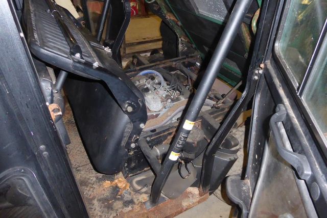 Inner cab of a Kawasaki KAF950G truck with hydraulic components and hoses visible.