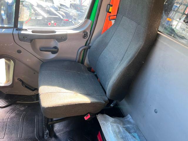Interior of a Freightliner M2 106 cab showing driver seat and door panel.