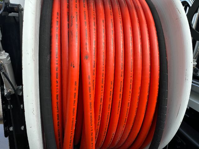01-06 Show: A reel of bright red hydraulic hoses wound on a spool mounted to a vehicle chassis.